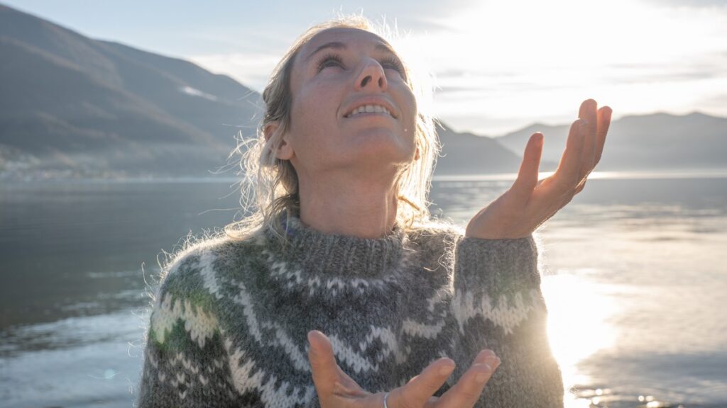 Mulher olhando para o céu com mãos erguidas demonstrando fé em esboço de pregação viver na dependência de Deus