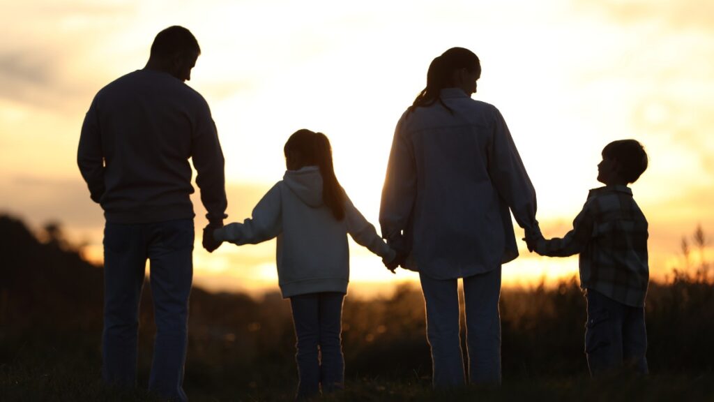Família de mãos dadas ao pôr do sol simbolizando cuidado de Deus em esboço de pregação família provisão de Deus
