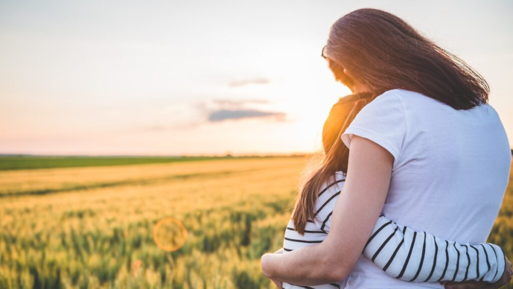 Mãe abraçando filha ao pôr do sol representando o verdadeiro valor de uma mãe esboço de pregação
