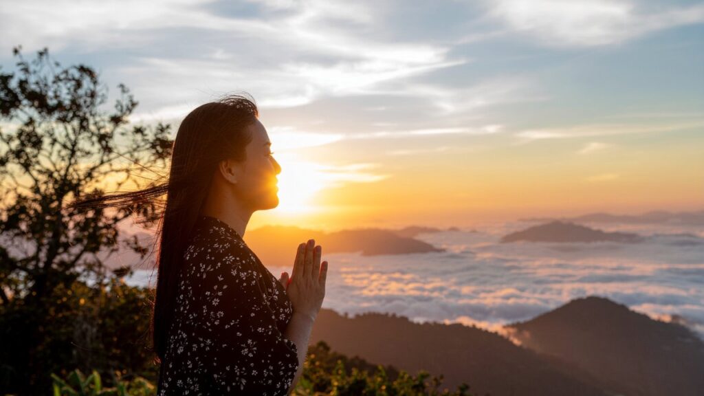 Mulher orando ao amanhecer nas montanhas simbolizando fé em esboço de pregação Lucas 7